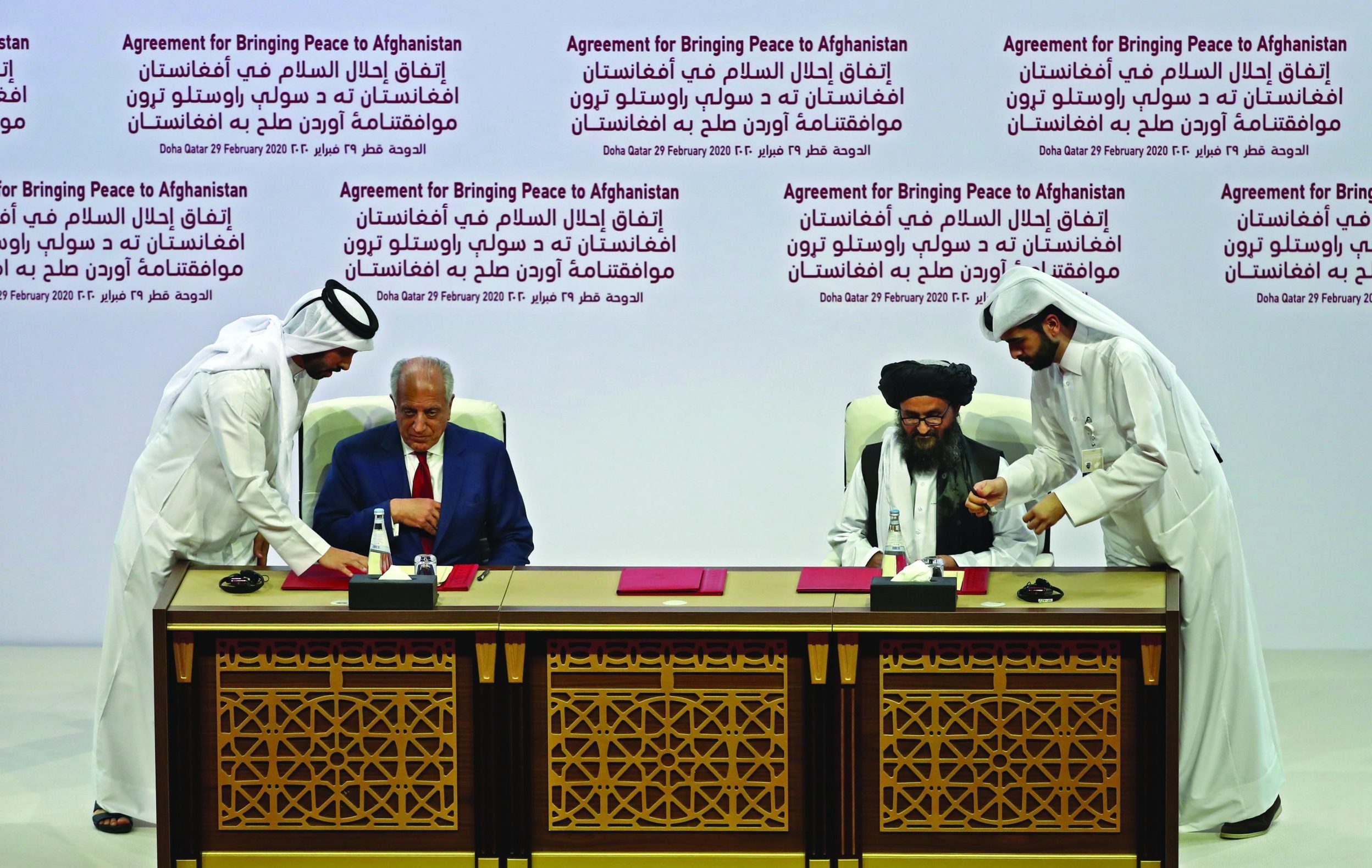 (L to R) US Special Representative for Afghanistan Reconciliation Zalmay Khalilzad and Taliban co-founder Mullah Abdul Ghani Baradar sign the US-Taliban peace agreement during a ceremony in the Qatari capital Doha on February 29, 2020. - The United States is signed a landmark deal with the Taliban, laying out a timetable for a full troop withdrawal from Afghanistan within 14 months as it seeks an exit from its longest-ever war. (Photo by KARIM JAAFAR / AFP)