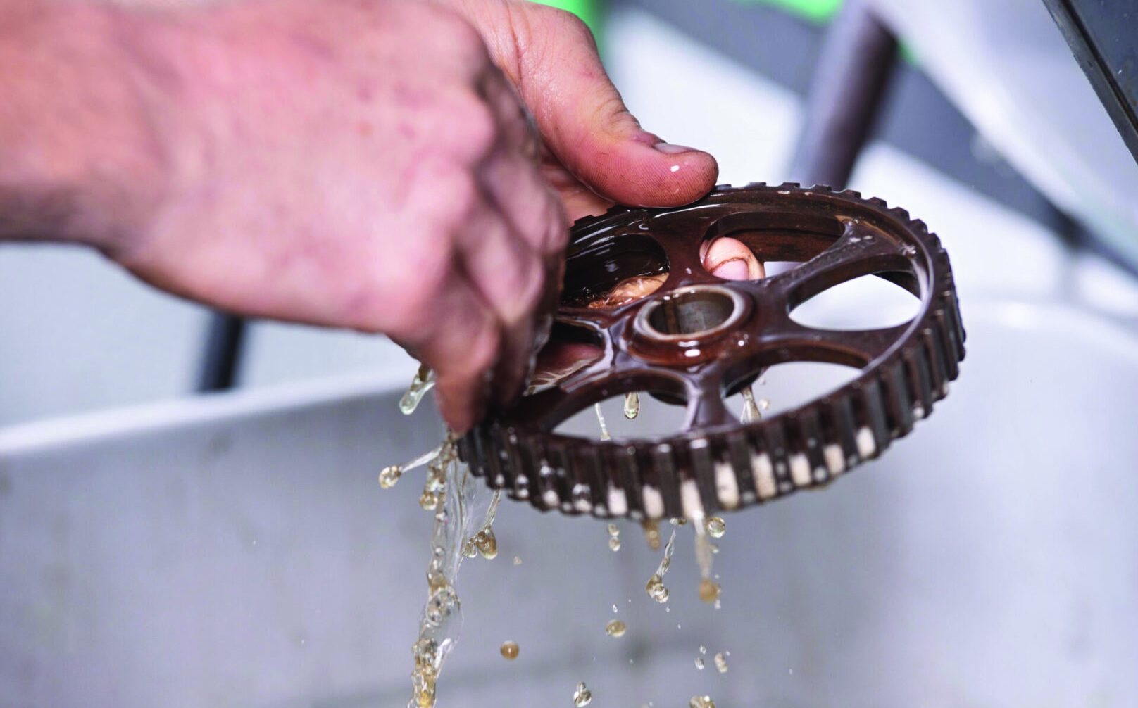 Car mechanic is cleaning and mantaining gear .